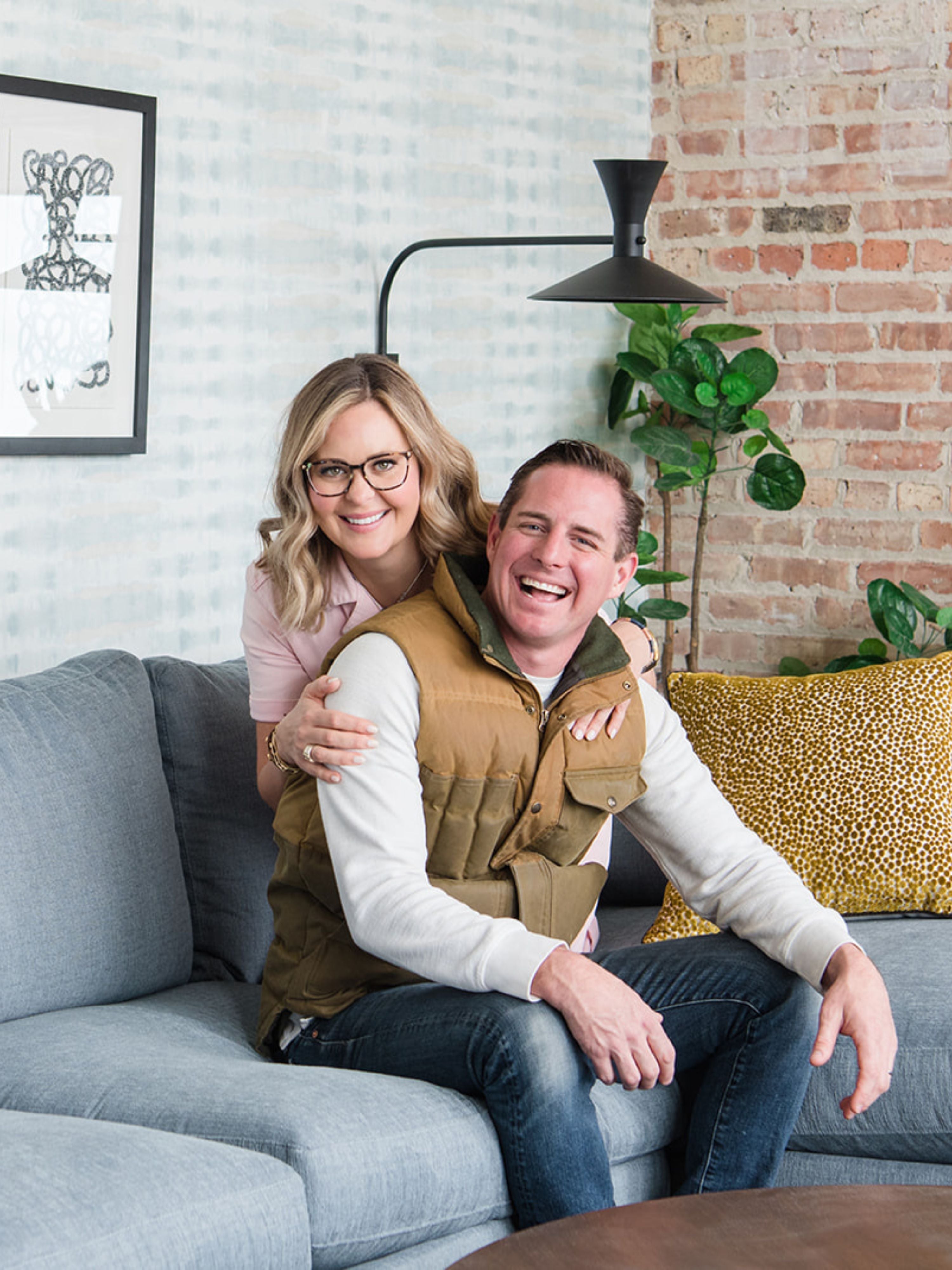 Meg and Joe Piercy sitting on a couch smiling 